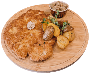 Kotlet schabowy smażony na smalcu z masłem czosnkowym, pieczonymi ziemniakami i zasmażaną kapustą